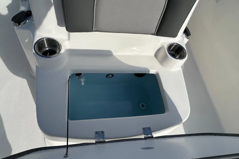 Slide: The Image of 2026 Sundance DX22 boat interior with cup holders and storage compartment. - 25