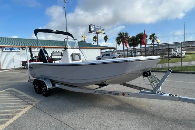 Slide: The Image of 2026 Sundance DX22 boat on trailer at marina, clear sky background. - 3