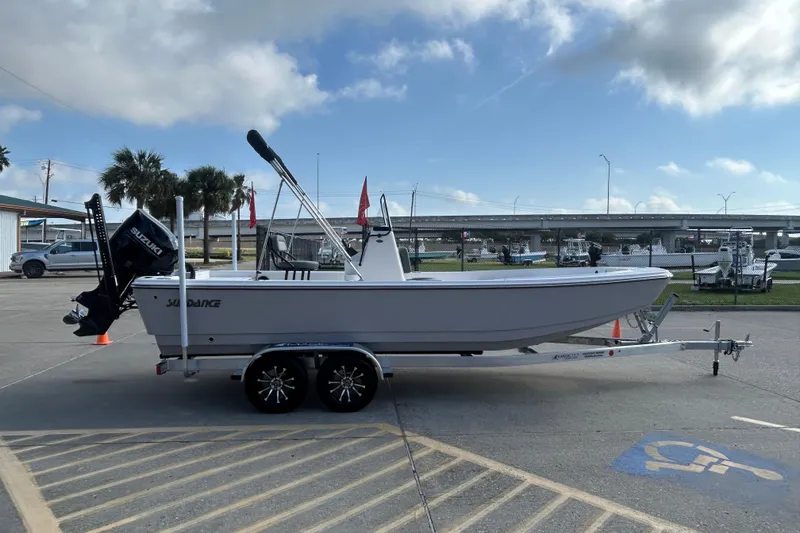Slide: The Image of 2026 Sundance DX22 boat on trailer, parked outdoors under cloudy sky. - 5