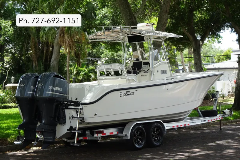 The Image of 2006 Edgewater 265CC boat on trailer with twin Yamaha engines, parked outdoors. - 0