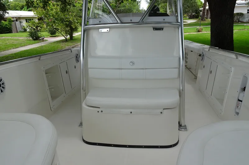 Slide: The Image of 2006 Edgewater 265CC boat interior with white seating and storage compartments. - 13