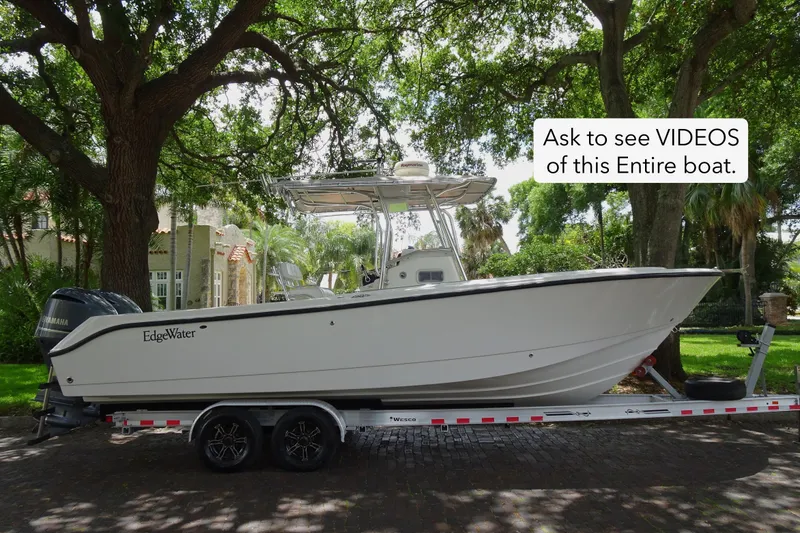 Slide: The Image of 2006 Edgewater 265CC boat on trailer, parked under trees, with video inquiry text. - 2