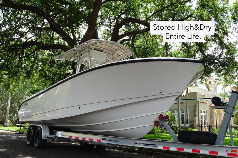 Slide: The Image of 2006 Edgewater 265CC boat on trailer, stored high and dry, under lush trees. - 3