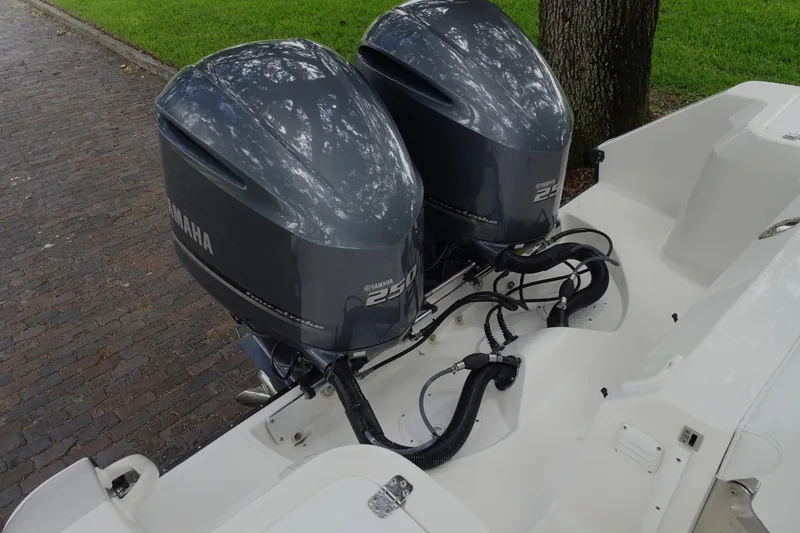 Slide: The Image of Twin Yamaha 250 outboard engines on a 2006 Edgewater 265CC boat, parked on a brick path. - 31