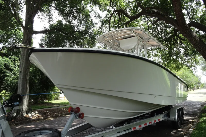 Slide: The Image of 2006 Edgewater 265CC boat on trailer under trees, showcasing sleek design. - 4