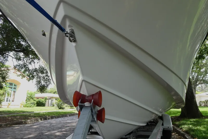 Slide: The Image of 2006 Edgewater 265CC boat on trailer, close-up of hull and bow, parked outdoors. - 5