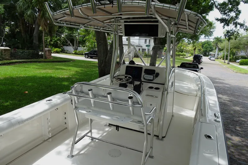 Slide: The Image of 2006 Edgewater 265CC boat with center console and T-top, parked on a residential street. - 9