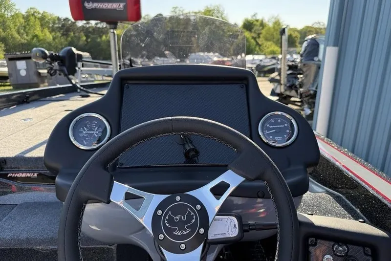 Slide: The Image of 2026 Phoenix 818 Pro boat dashboard with steering wheel and gauges, outdoors. - 11