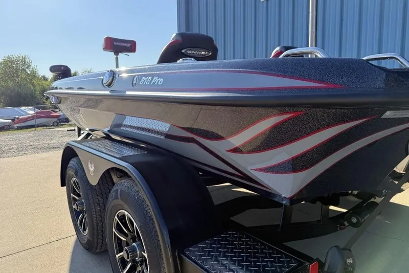 Slide: The Image of 2026 Phoenix 818 Pro boat with sleek design and custom graphics, parked outdoors. - 7
