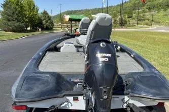 Slide: The Image of 2006 Stratos 275 Pro XL boat with Evinrude motor, parked on a sunny day. - 9