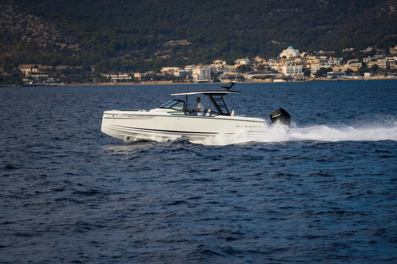 Slide: The Image of A 2027 Saxdor 270 GTO speeds across the water near a coastal town. - 41