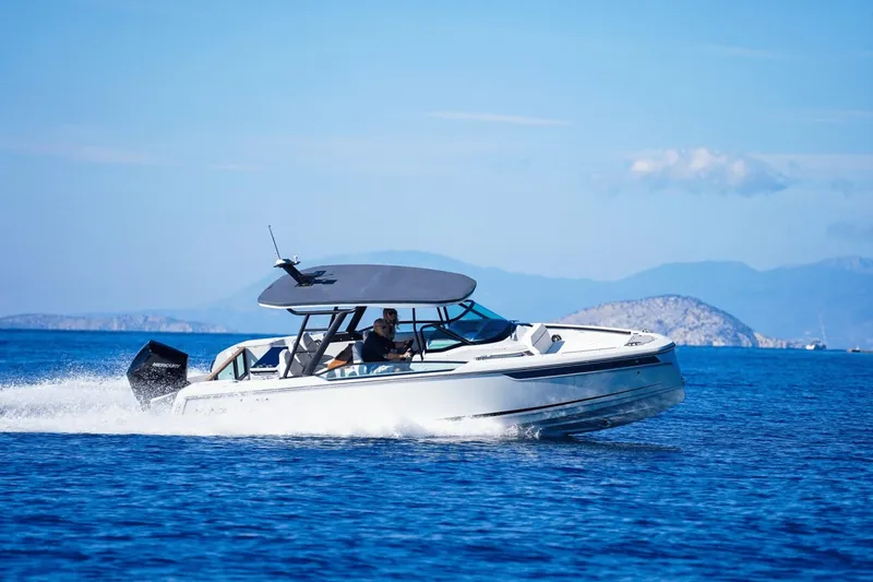 Slide: The Image of A Saxdor 270 GTO boat speeds across blue water, with mountains in the background. - 32