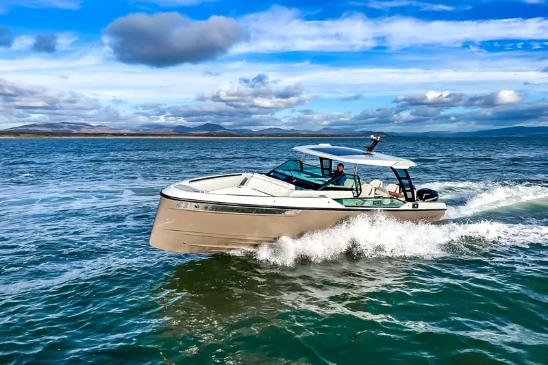 Slide: The Image of A 2027 Saxdor 320 GTO speeds across the water under a blue sky. - 27