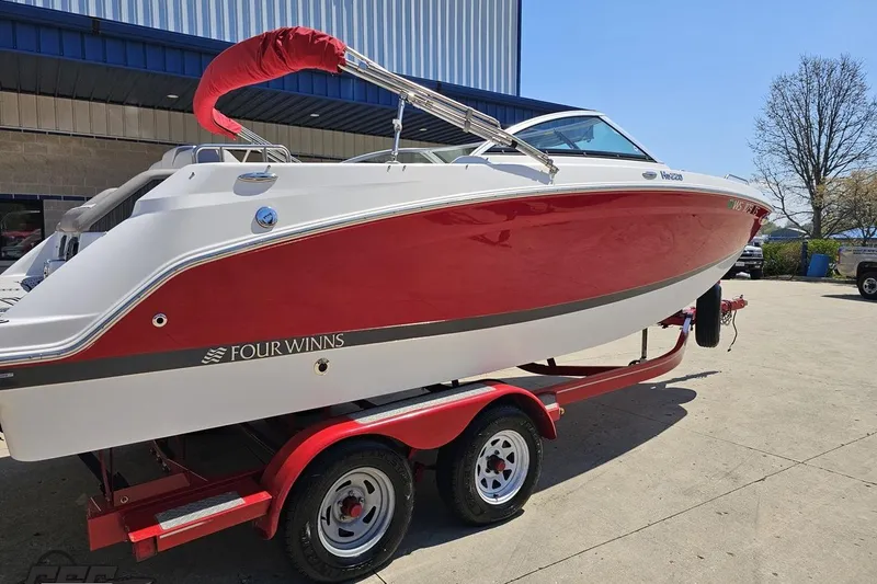 Slide: The Image of 2018 Four Winns HD220 boat on trailer, red and white design, parked outdoors. - 10
