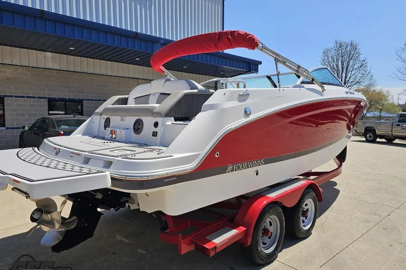Slide: The Image of 2018 Four Winns HD220 boat on trailer, red and white design, parked outdoors. - 11