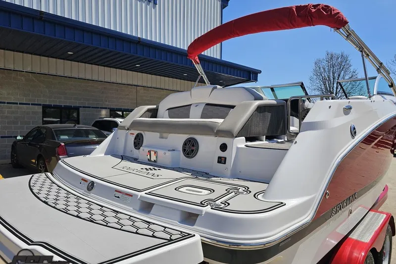 Slide: The Image of 2018 Four Winns HD220 boat with red canopy, parked outside a building. - 12