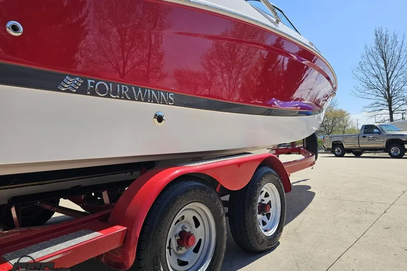 Slide: The Image of 2018 Four Winns HD220 boat on red trailer, parked outdoors. - 13