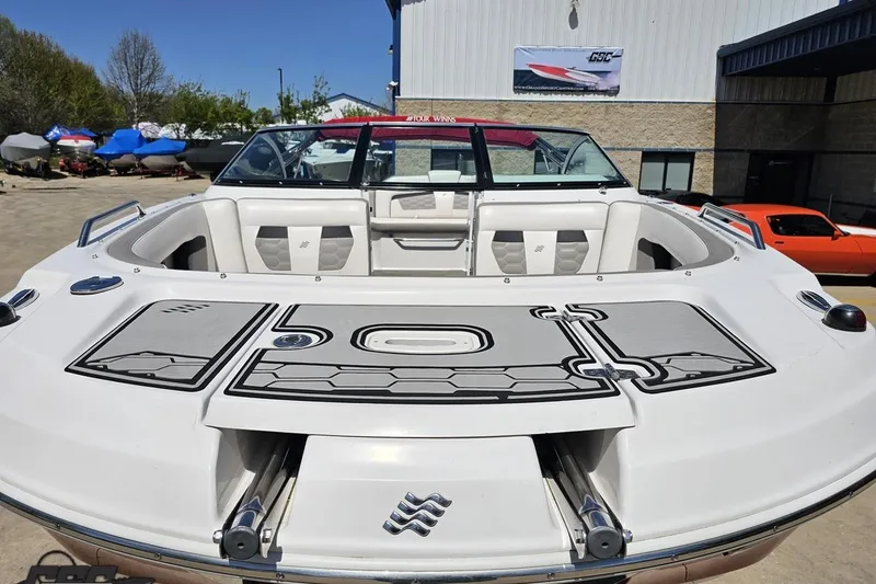 Slide: The Image of 2018 Four Winns HD220 boat with spacious seating and sleek design in a marina setting. - 18