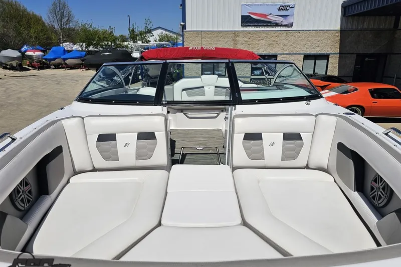 Slide: The Image of 2018 Four Winns HD220 boat interior with white seating, parked outdoors. - 19