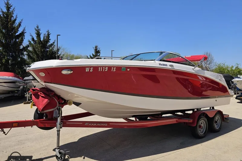 Slide: The Image of 2018 Four Winns HD220 boat on trailer, red and white design, parked outdoors. - 22