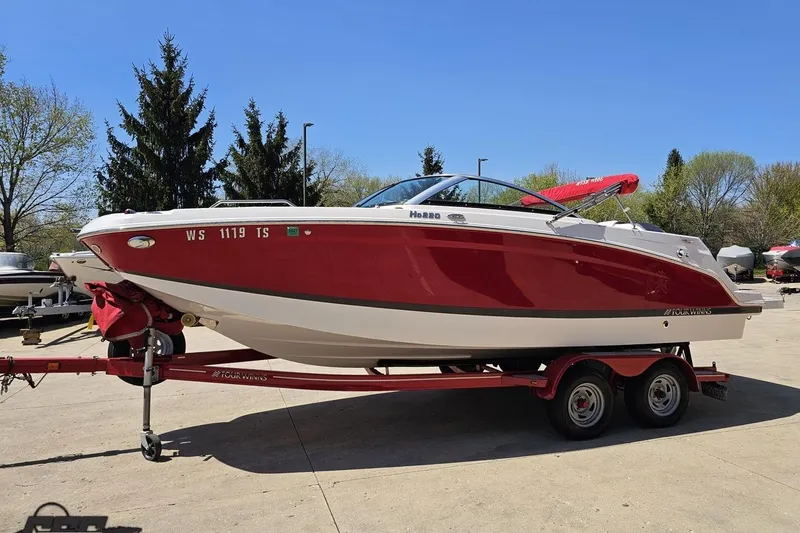 Slide: The Image of 2018 Four Winns HD220 boat on trailer, red and white, parked outdoors. - 23