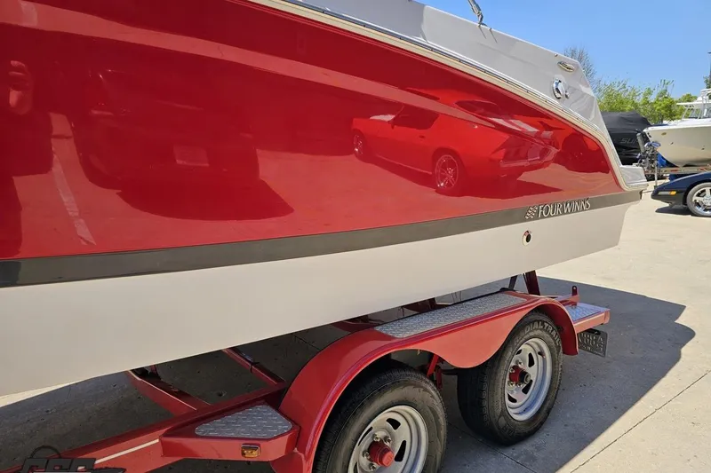 Slide: The Image of 2018 Four Winns HD220 boat on a red trailer, side view. - 27