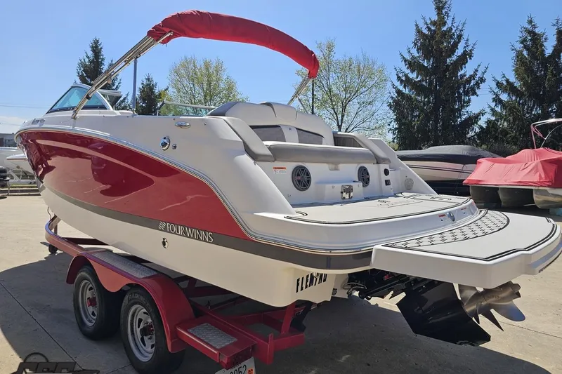 Slide: The Image of 2018 Four Winns HD220 boat with red and white design on a trailer. - 31