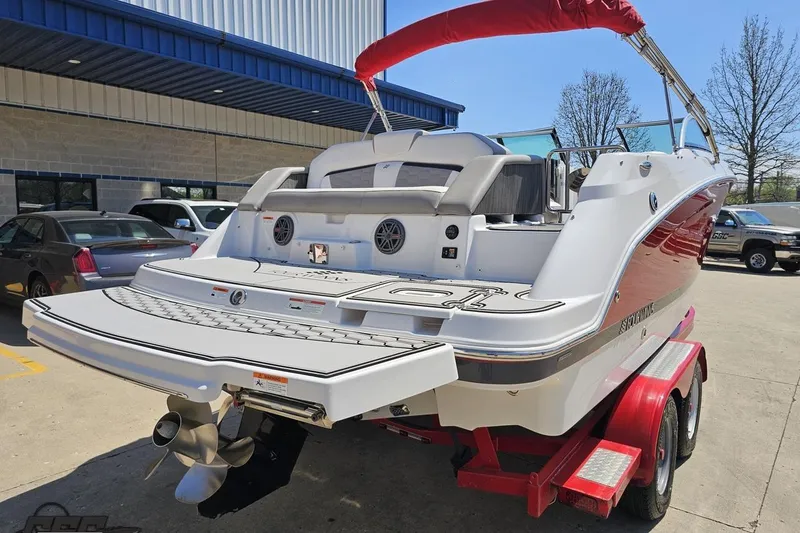 Slide: The Image of 2018 Four Winns HD220 boat on trailer, parked outdoors near a building. - 34
