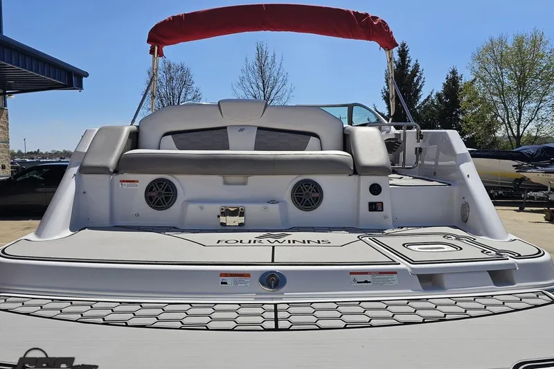 Slide: The Image of 2018 Four Winns HD220 boat with spacious seating and sleek design, docked outdoors. - 35