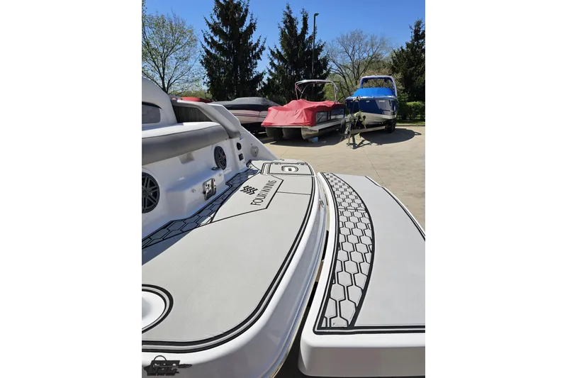Slide: The Image of 2018 Four Winns HD220 boat with sleek deck design, parked outdoors under clear skies. - 38