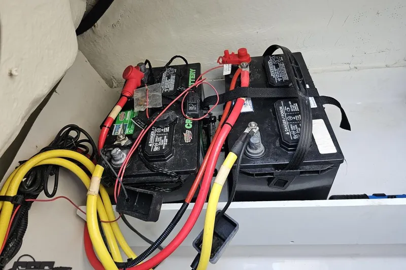 Slide: The Image of 2018 Four Winns HD220 boat battery compartment with dual batteries and wiring. - 47