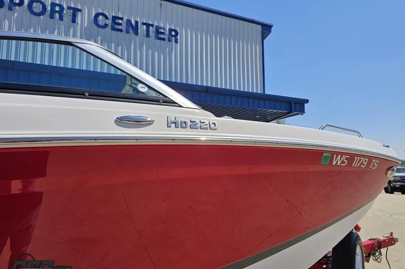 Slide: The Image of 2018 Four Winns HD220 boat with red hull at a sport center. - 5