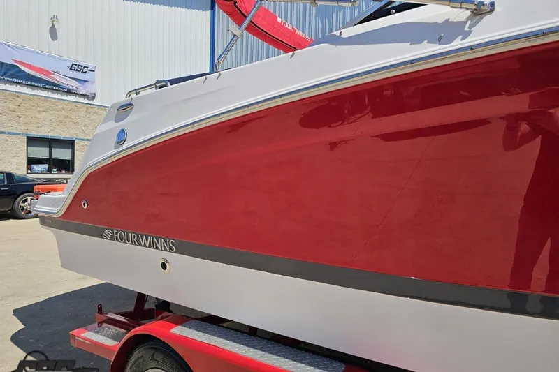 Slide: The Image of 2018 Four Winns HD220 boat with red and white exterior on a trailer. - 6