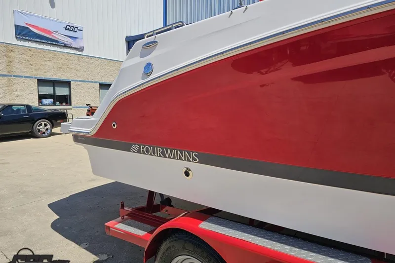 Slide: The Image of 2018 Four Winns HD220 boat with red and white exterior on a trailer. - 7
