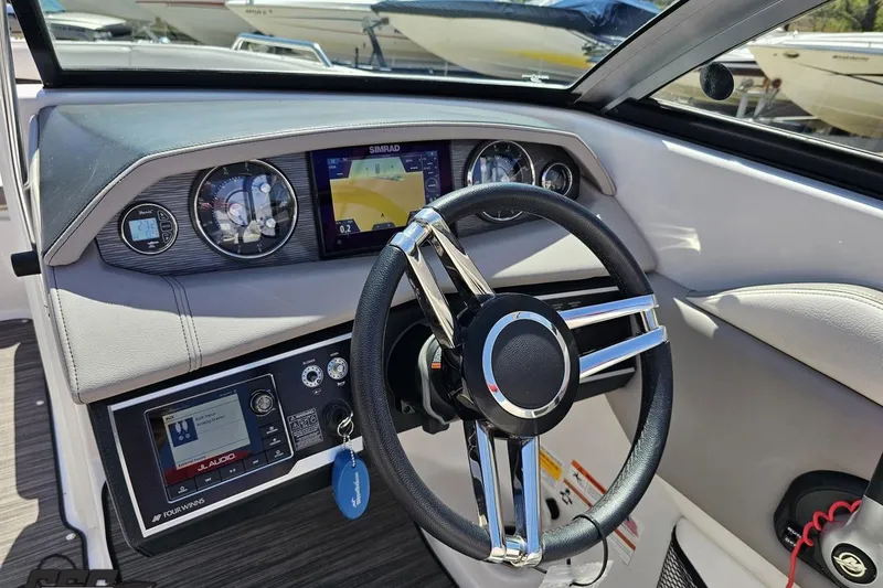 Slide: The Image of 2018 Four Winns HD220 boat dashboard with steering wheel and navigation display. - 73