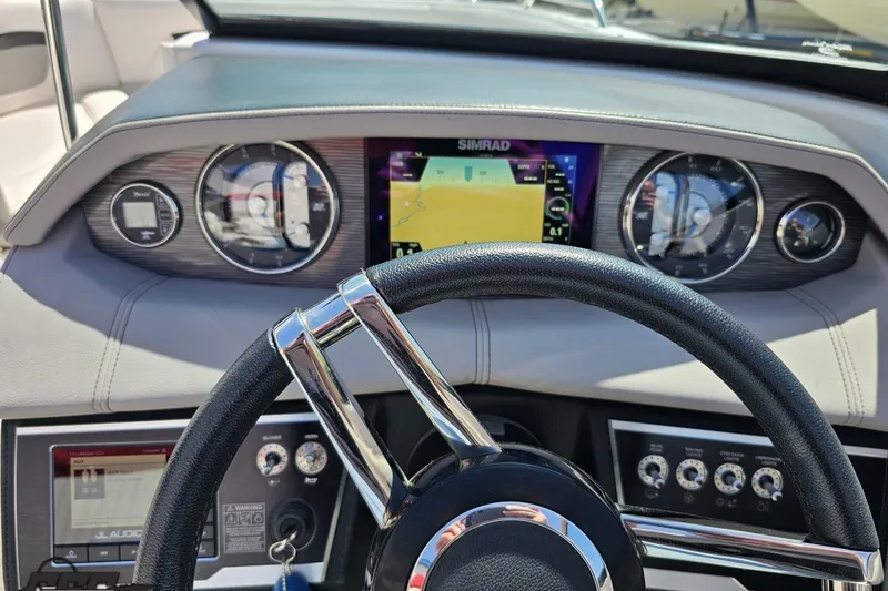 Slide: The Image of Dashboard of a 2018 Four Winns HD220 boat with steering wheel and navigation display. - 75