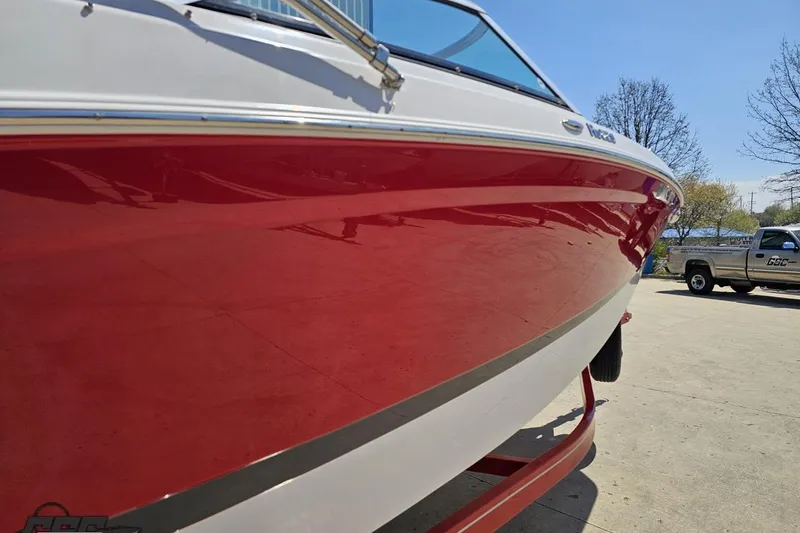 Slide: The Image of 2018 Four Winns HD220 boat with a sleek red hull, parked outdoors. - 8