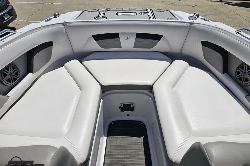 Slide: The Image of 2018 Four Winns HD220 boat interior with white cushioned seating and speakers. - 83