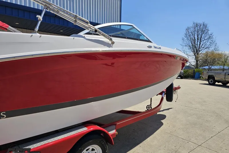 Slide: The Image of 2018 Four Winns HD220 boat with red and white exterior on a trailer. - 9