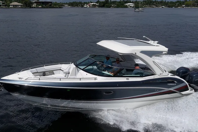 Slide: The Image of 2022 Formula 310 Bowrider OB cruising on a calm lake with passengers onboard. - 19