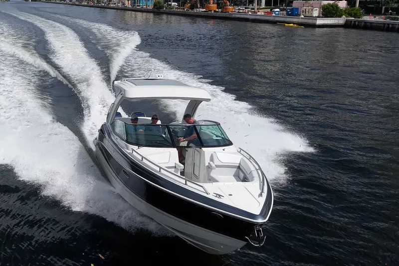Slide: The Image of 2022 Formula 310 Bowrider OB cruising on a waterway, creating dynamic waves. - 24