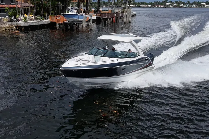 Slide: The Image of 2022 Formula 310 Bowrider OB cruising on a scenic waterway near docks and palm trees. - 21