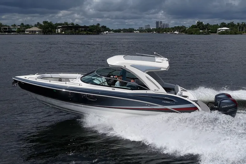 Slide: The Image of 2022 Formula 310 Bowrider OB cruising on a scenic waterway under cloudy skies. - 16