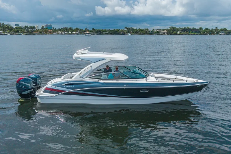 Slide: The Image of 2022 Formula 310 Bowrider OB cruising on a calm lake under a cloudy sky. - 2