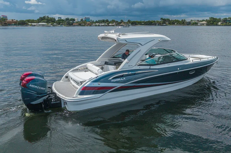 Slide: The Image of 2022 Formula 310 Bowrider OB boat on water, featuring sleek design and Mercury outboard engines. - 14
