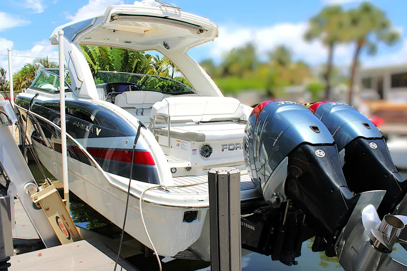 Slide: The Image of 2022 Formula 310 Bowrider OB with dual outboard engines docked in a sunny marina. - 3