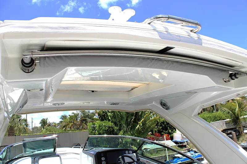 Slide: The Image of 2022 Formula 310 Bowrider OB boat canopy and interior view under clear blue sky. - 33