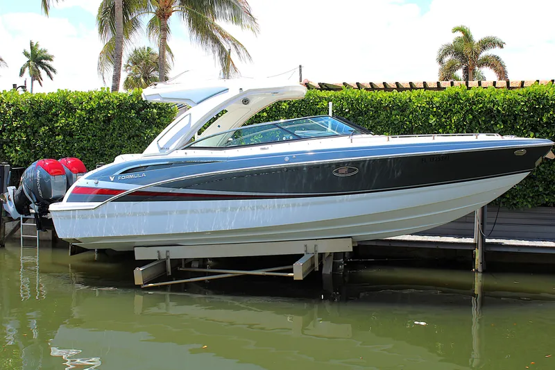 Slide: The Image of 2022 Formula 310 Bowrider OB boat docked, surrounded by lush greenery and palm trees. - 37