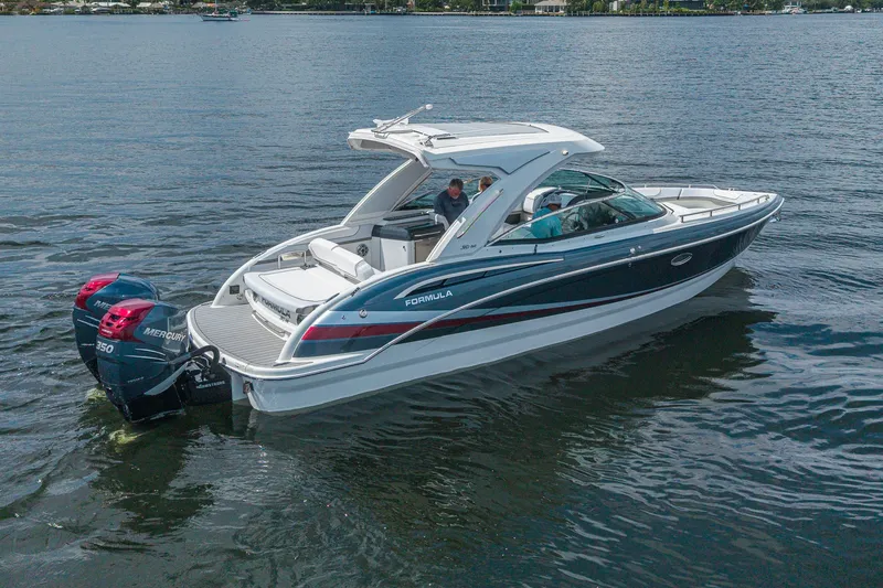 Slide: The Image of 2022 Formula 310 Bowrider OB boat cruising on a calm lake with dual Mercury engines. - 1