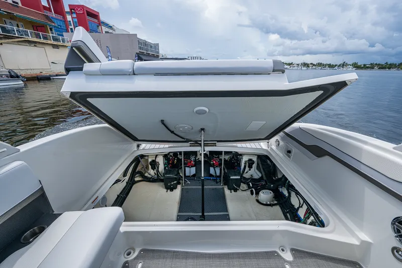 Slide: The Image of 2022 Formula 310 Bowrider OB engine compartment open, showcasing interior mechanics by the waterfront. - 68